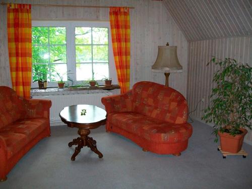 a living room with a couch and a chair and a table at Jägerlehrhof, Breiholz in Breiholz