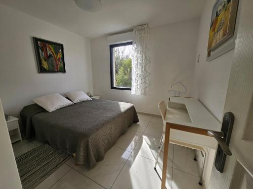 une chambre avec un lit, un bureau et une fenêtre dans l'établissement Agréable appartement vue mer à Bandol Piscine, à Bandol