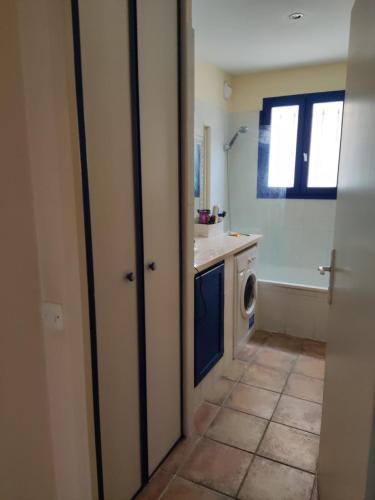 une salle de bain avec un lavabo et une machine à laver dans l'établissement 2-room apartment with a magnificent view of the sea, in carqueiranne in the var, 12km from the isles de porquerolles boarding port – 2/4 people, à Carqueiranne