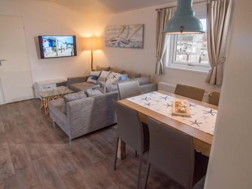a living room with a table and a couch at Strand 13 in Scharbeutz