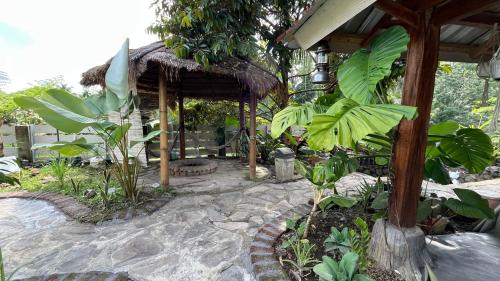a garden with a pavilion with trees and plants at kunang kunang in Tetebatu