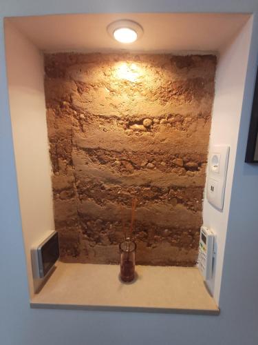 a room with a stone wall and a vase on a shelf at Chambre d'hotes Mas Pékin in Mas-Thibert