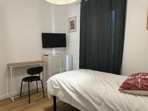 une chambre avec un lit et un bureau avec une télévision dans l'établissement M97 Marquer joli studio Faucigny, à Annemasse