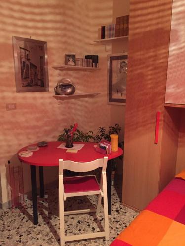 a red table with a chair in a room at A casa di mamma in Rieti