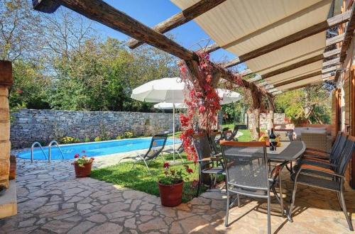 a patio with a table and chairs next to a pool at Villa Katherine with Pool and Game Room in Žminj