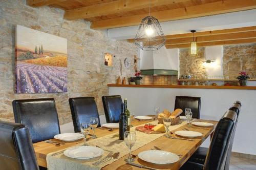a dining room with a wooden table and chairs at Villa Katherine with Pool and Game Room in Žminj