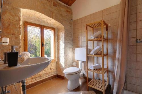 a bathroom with a tub and a sink and a toilet at Villa Katherine with Pool and Game Room in Žminj
