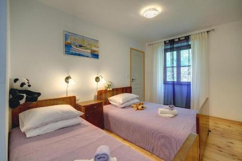 a bedroom with two beds with stuffed animals on them at Villa Katherine with Pool and Game Room in Žminj