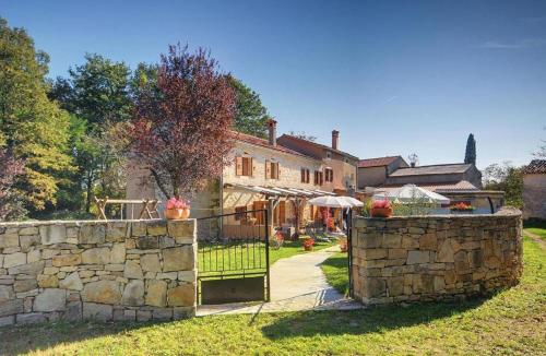 a stone fence in front of a house at Villa Katherine with Pool and Game Room in Žminj