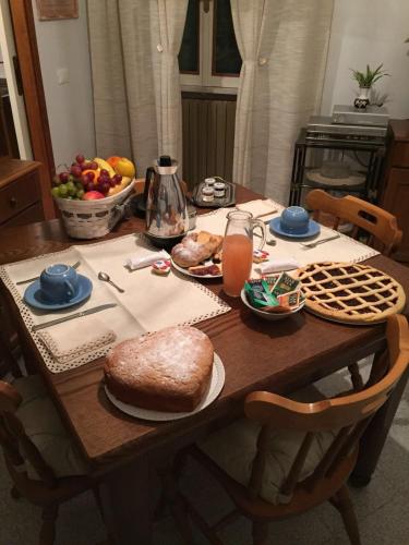 a wooden table with a cake and a bowl of fruit at A casa di mamma in Rieti