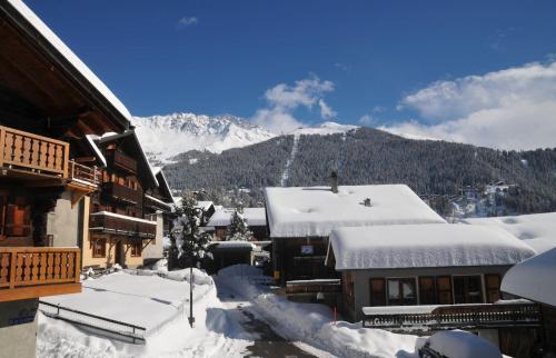 a snow covered village with a mountain in the background at Laiterie 1 in Verbier