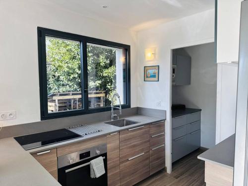 a kitchen with a sink and a window at Ty Kerbihan, confortable maison au calme, 200m plage in La Trinité-sur-Mer