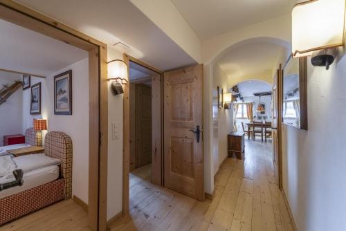 a hallway with a room with a bed and a door at Chesa Champagna - Madulain in Madulain