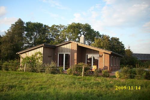une petite maison en briques dans un champ avec de l'herbe dans l'établissement Bauernhof Sauer - Kötterhus, à Varel