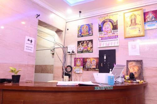 a counter in a room with posters on the wall at Grand D Gala , Dharmapuri in Dharmapuri