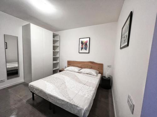 a bedroom with a bed in a white room at Scala Santa Apartment in Trieste
