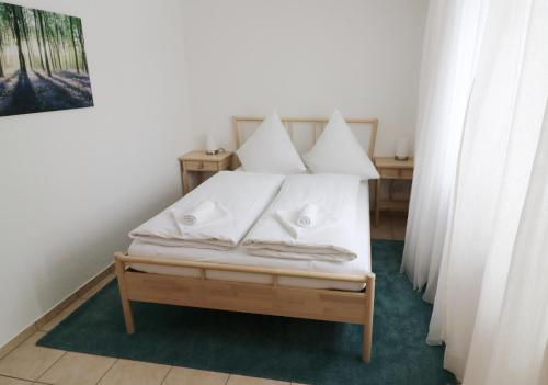 a bedroom with a bed with white sheets and pillows at Haus Findling, 10 Personen, Schluchsee, Hochschwarzwaldkarte in Schluchsee