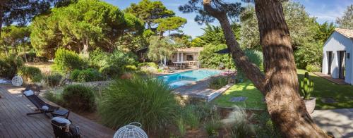 une cour arrière avec une piscine et une maison dans l'établissement Villa Petit Marchais, aux Portes
