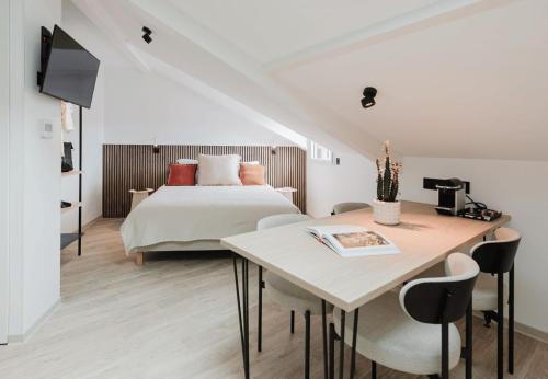 a bedroom with a bed and a table with a tableablish at Appart Hotel Neostelia in Annecy