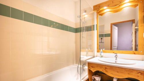 une salle de bain avec un lavabo, une baignoire et un miroir dans l'établissement V du Bachat - Melezes E13 - 5 pers, à Chamrousse