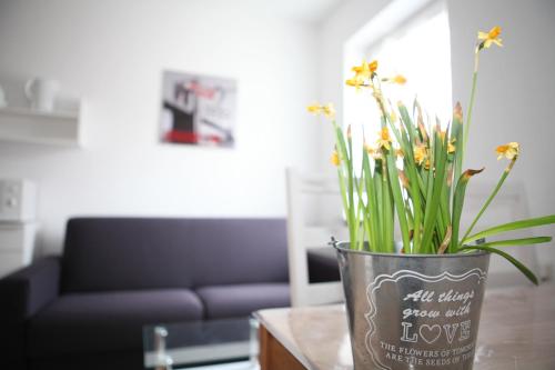 a vase filled with flowers sitting on a table at Bermuda Apartment in Bochum