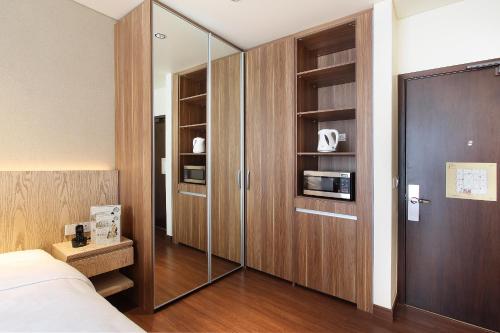 a bedroom with a large wooden closet with glass doors at Dwijaya House of Pakubuwono in Jakarta
