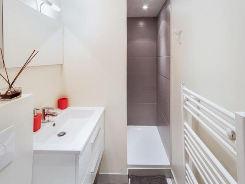 ein weißes Badezimmer mit Waschbecken und Dusche in der Unterkunft Studio triangle d'Or in Bordeaux
