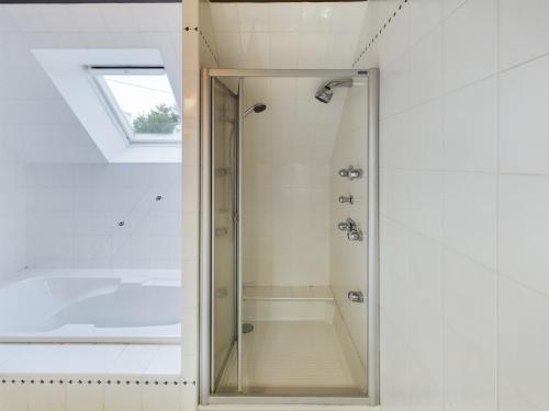 une douche avec une porte vitrée dans une salle de bain dans l'établissement -NAYA- Maison familiale a deux pas de la mer, à Trégunc