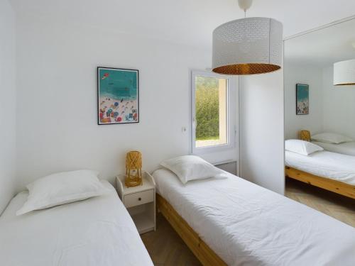 une chambre avec deux lits et une fenêtre dans l'établissement -NAYA- Maison familiale a deux pas de la mer, à Trégunc