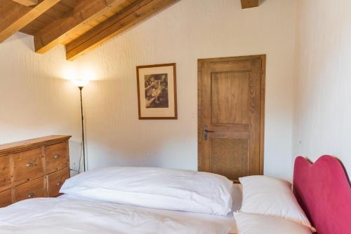 a bedroom with a bed and a wooden door at Chesa Seja - Zuoz in Zuoz