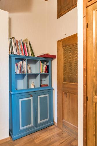 a blue book shelf sitting next to a door at Chesa Seja - Zuoz in Zuoz