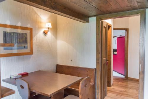 a dining room with a table and a pink door at Chesa Seja - Zuoz in Zuoz