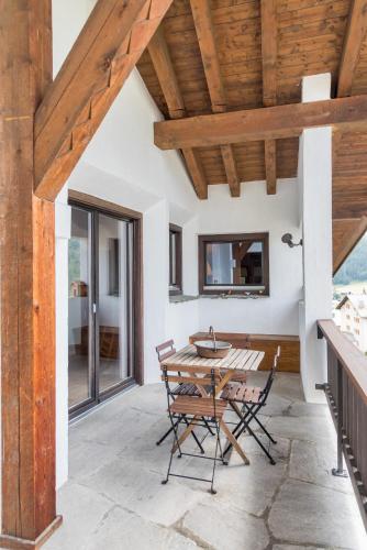 a patio with a wooden ceiling and a table and chairs at Chesa Seja - Zuoz in Zuoz