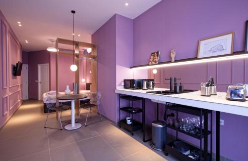 a kitchen with purple walls and a table with chairs at Osito Hub - Llorens in Valencia