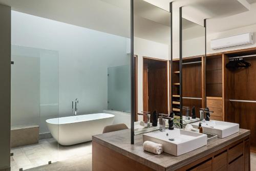 a bathroom with two sinks and a tub at Luxury villa 5 bdr oceanfront 5 min walk to cenote in Puerto Aventuras