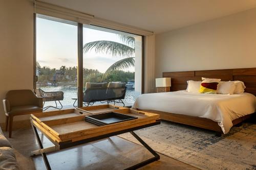 a bedroom with a bed and a coffee table and a window at Luxury villa 5 bdr oceanfront 5 min walk to cenote in Puerto Aventuras