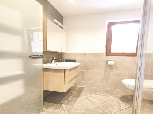 a bathroom with a sink and a toilet at Exclusive apartment with garden and whirlpool in Ramsau