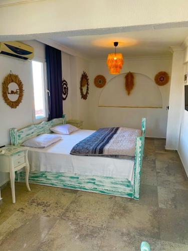 a bedroom with a bed and a chandelier at Hotel Barba in Urla