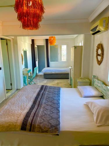 a bedroom with a large bed with a chandelier at Hotel Barba in Urla