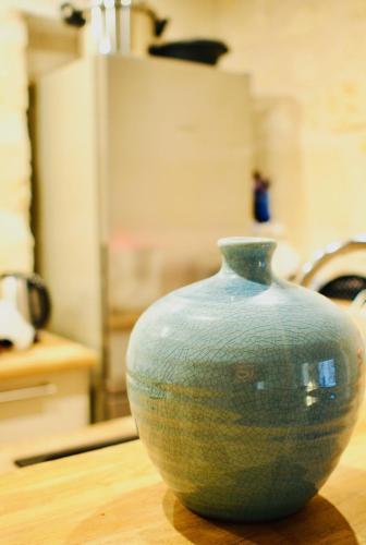 un vase bleu assis au-dessus d'une table en bois dans l'établissement Esprit Bordelais, à Bordeaux