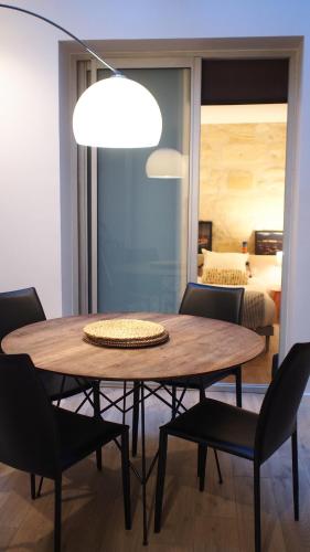 - une salle à manger avec une table, des chaises et un lit dans l'établissement Esprit Bordelais, à Bordeaux