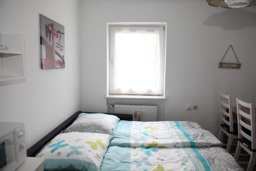 a small bedroom with a bed and a window at Bermuda Apartment in Bochum