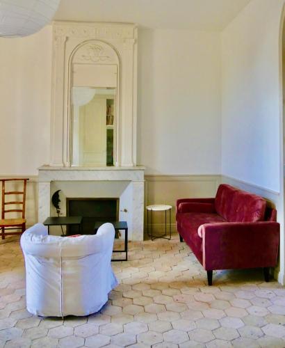 un salon avec un canapé rouge et un miroir dans l'établissement Douceur Girondine, à Saint-Selve