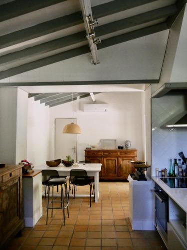 une cuisine avec une table et des chaises dans une pièce dans l'établissement Douceur Girondine, à Saint-Selve
