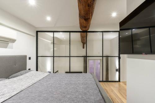 - une chambre avec un lit et des parois en verre dans l'établissement Cocon au cœur du Vieux Nice, à Nice