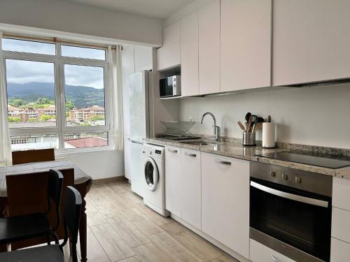 a kitchen with white cabinets and a dishwasher at EARRA- Pagoeta - cerca de la playa y centro in Zarautz