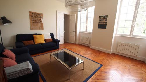 a living room with a couch and a glass table at Domaine de Gorre in Martillac