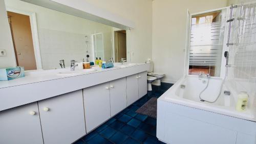 a bathroom with two sinks and a tub and a toilet at Domaine de Gorre in Martillac