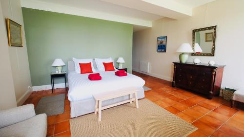 a bedroom with a large white bed with red pillows at Domaine de Gorre in Martillac