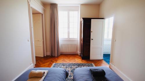 a living room with a blue couch and a window at Domaine de Gorre in Martillac